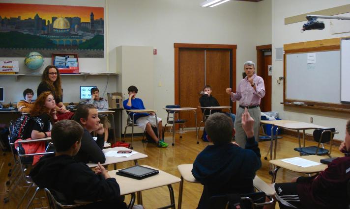 A student raises his hand to ask Ms. Decarreau a question.