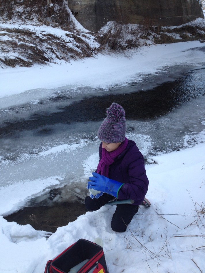 BFA HS student Rebekah Larose collects water samples at Black Creek in East Fairfield, VT