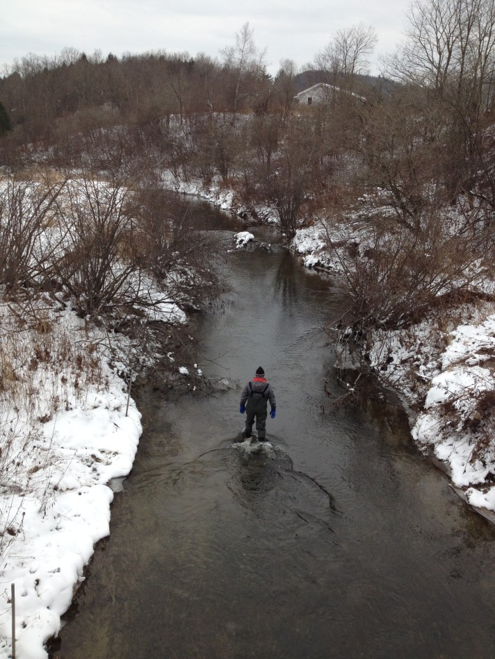 BFA High School Science Teacher Tom Lane wades up Black Creek to remove temperature and stage sensors earlier this winter.
