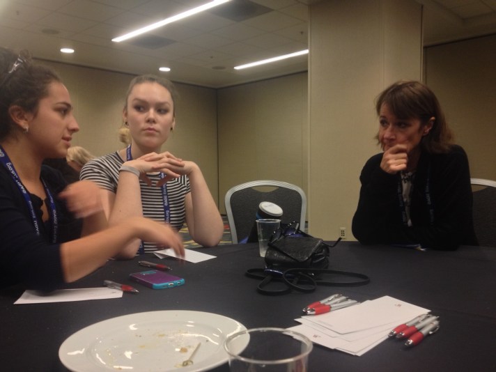 Left to right, Rebekah Larose and Sophie Lee describe their research to the President of the American Geophysical Union, Geophysicist Carol Finn at a luncheon for student researchers.