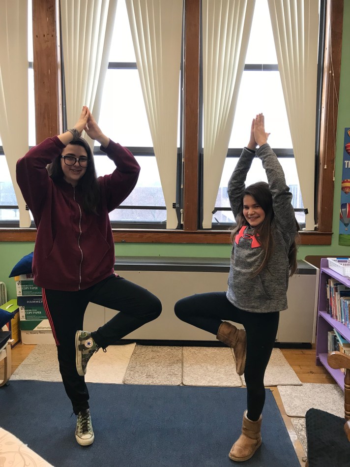 students in a yoga pose during sensory break