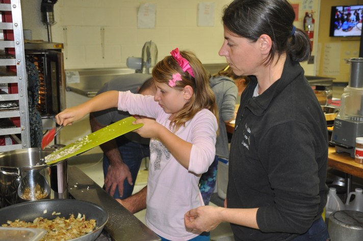 A student cooks in the kitchen at Fletcher Elementary School