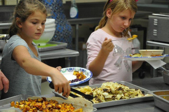 Students serve their harvested vegetables prepared in the Fletcher Elementary School kitchen
