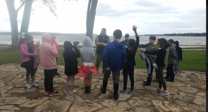 Students discuss their lake learning on the shores of Lake Champlain